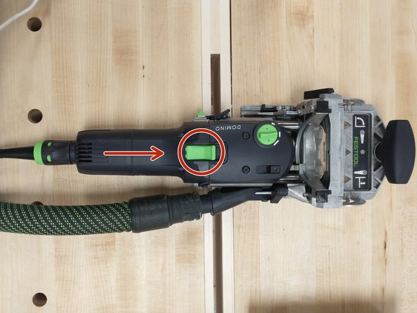 Hold the front knob and align the machine where you want a hole.