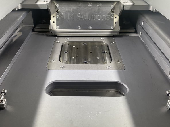 To start clean the plate mounting surface with the inerted vacuum and ensure that there is no powder in the screw holes.