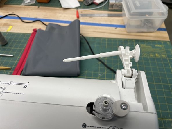 Open the thread spool holder. you should hear a click.