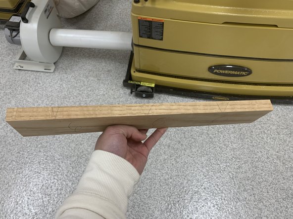 Use two push blocks with one on the top edge pushing down into outfeed table and the other along the face pushing into the fence.