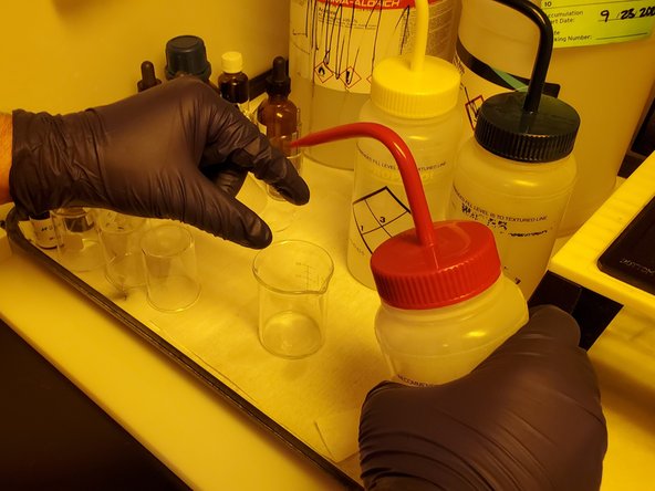 Ready a large beaker to catch the chemicals as you use them to rinse the slide.