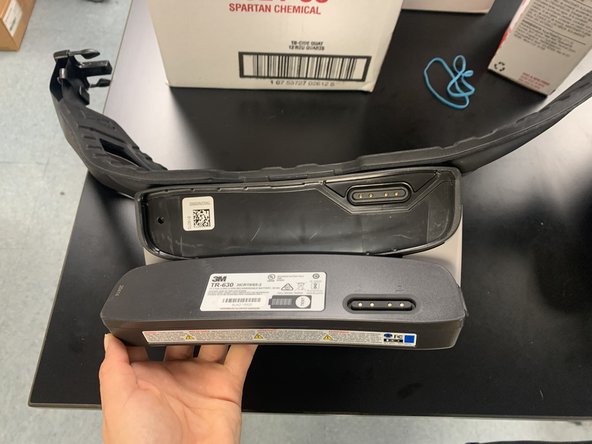 Aligning the strip on the battery to the strip on the waistband