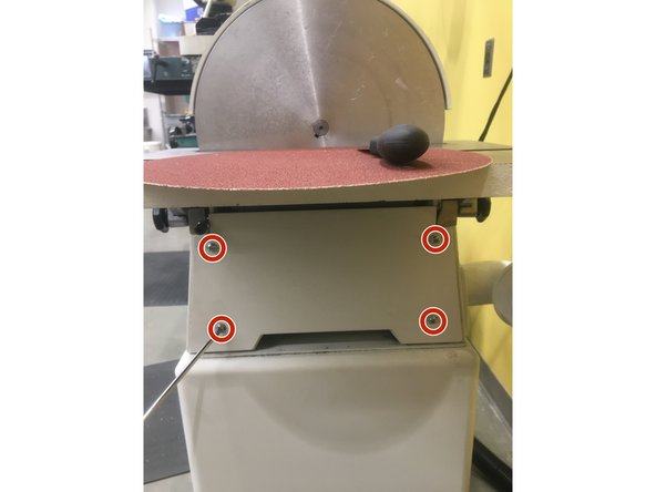 Using a screwdriver, unscrew the four screws holding in the lower cover. Once the cover is removed, vacuum up any dust.