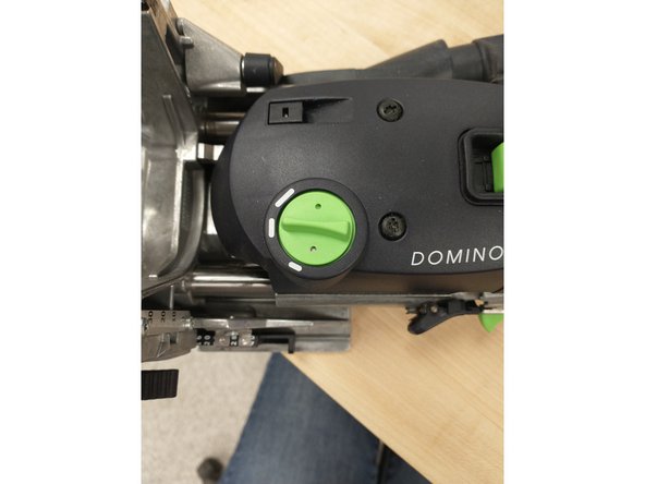 WITH THE MACHINE ON, turn the knob to the desired domino width.