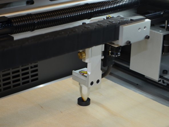 Loosen the thumbscrew to the left of the focusing lens.