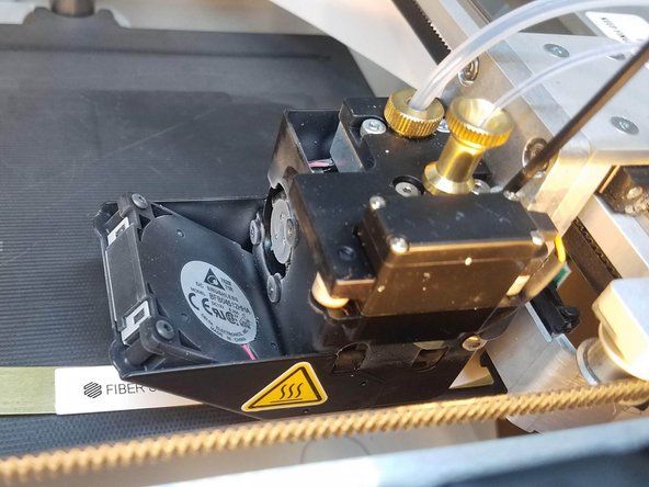 Slide the fiber shim between the nozzle and the print bed and press Next