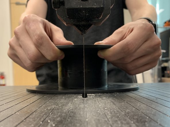 Hold the spool by the top disc and make sure you prevent the blade from pulling it down when cutting.