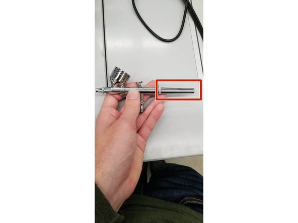 Unscrew back of airbrush to expose the end of the needle.