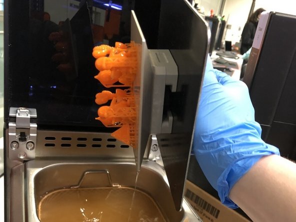 Once the washing is complete, carefully remove the build plate from the washing tank and inspect the parts for any residual resin.