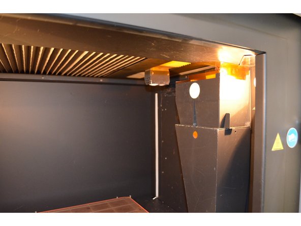 Reinstall all the components of the tip cleaning assembly, as well as the debris chute hood