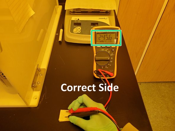 Use a multimeter to detect the conducting side, which is the side with the ITO coating.
