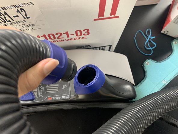 Place the hose that is attached to the head cover into the hole at the top of the waistband.