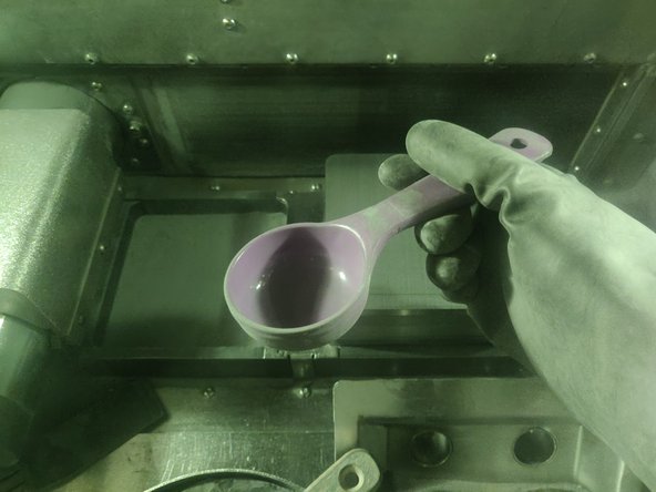 As canisters are emptied, place the first 2 empty canisters in the waste powder compartment, where they were when you first removed them at the beginning of this Dozuki. Make sure the metal funnel plate is properly in place and won't slide around.