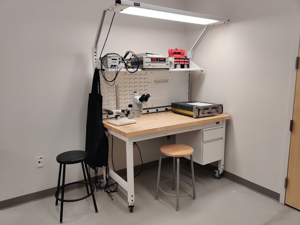 The three workbenches along the wall house basic electronics equipment.