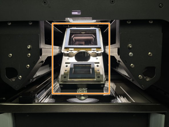Loosen the screw in the front-center of the print bed, SLOWLY LOWER the tray holding the laser window.