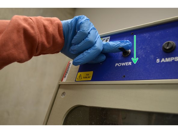 Flip the switch down to turn on the washer, and up to turn it back off. When on, the overhead LED lights should flash on.