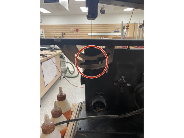 Turn the black handle counterclockwise to unlock the work table.