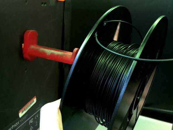 Tuck the filament into the spool using the two little holes on the edge
