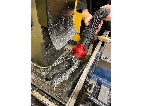 Use the vacuum to clean the chips behind the vice