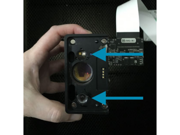 Grasp the printer head as shown, and pull gently up and back to disengage the magnets and remove it