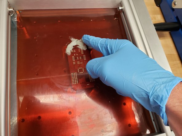 Use a glove to place a small glob of solder paste on the stencil.