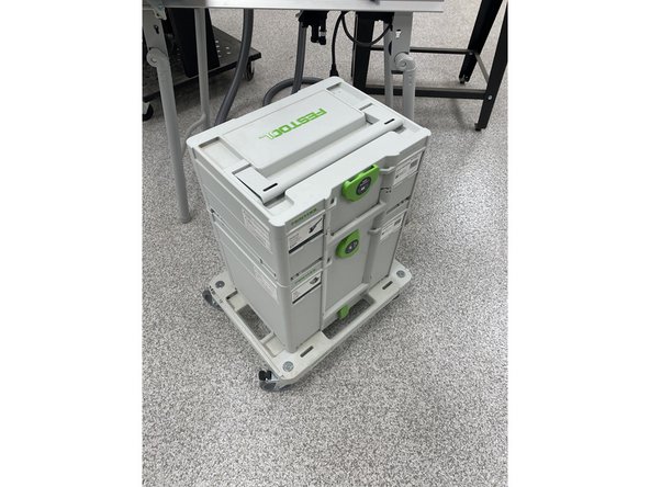 The hand sander is located in one of the FESTOOL branded cases around the woodshop.