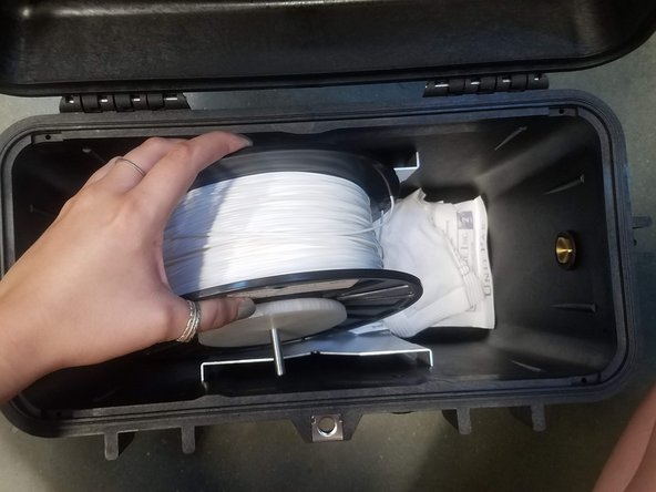 Place the spindle in the drybox such that the plastic filament exits from the top of the spool