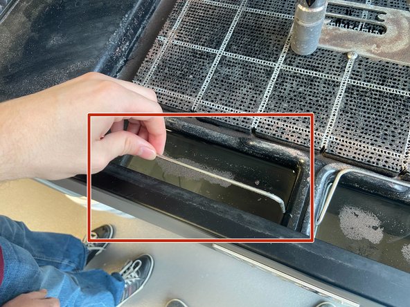 Lift the handle of the used garnet bucket. This doubles as the lock to keep the buckets in place