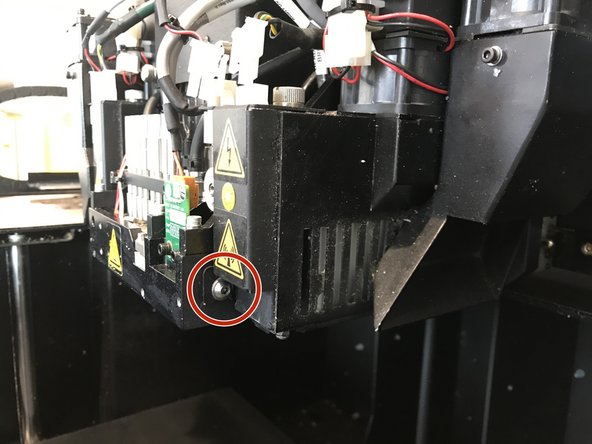 Supporting the entire UV lamp with one hand, unscrew the screw circled using the larger of the two allen wrenches