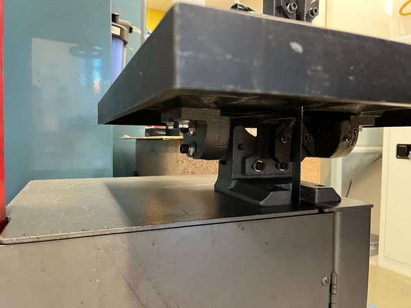 Use the brush and dustpan to clean below the table.