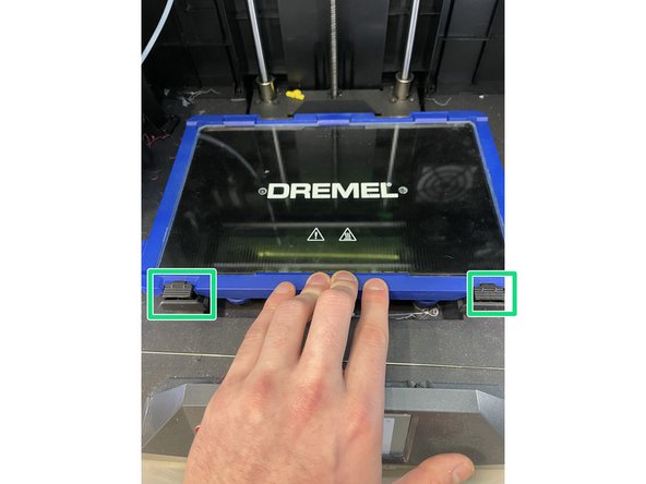 Push down on the front side of the plate near the black clips to lock it back into place