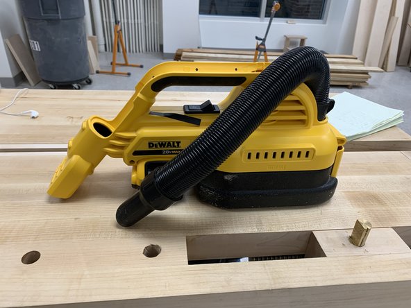 A handheld DeWalt hand vacuum that helps you clean dust as you go.