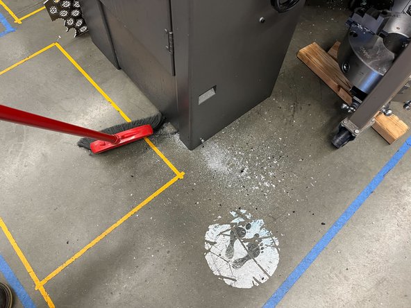 Using a broom and dustpan, sweep up any remaining dust on the floor and throw away in the trash.