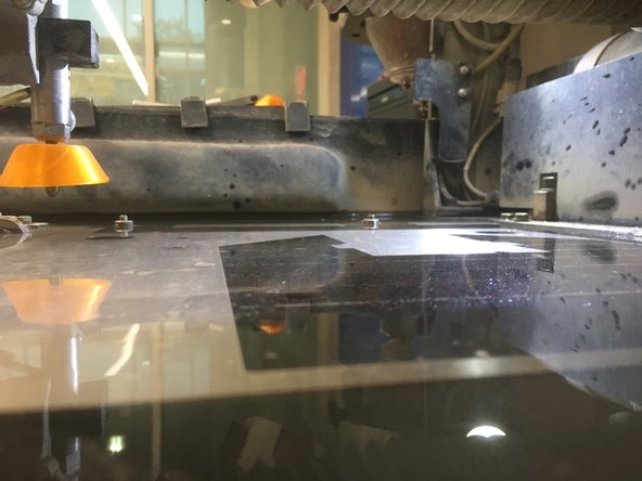 Use the hose in the sink next to the waterjet to raise the water level in the machine until it is just above the stock material