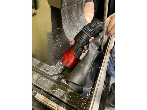 Use the vacuum to clean the chips behind the vice