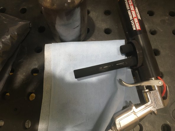 Using the air gun set to no higher than 10  PSI blow off any remaining powder of the previous color, making sure to blow through the air gun's tubes