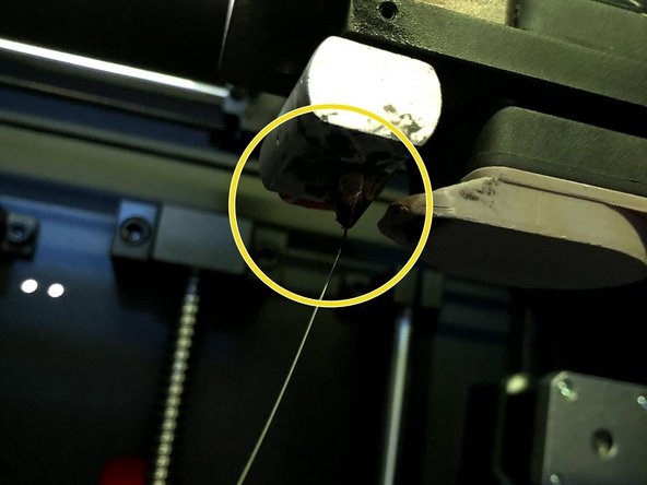 Remove the PTFE tube from the plastic bracket at the top of the extruder by pulling lightly upwards