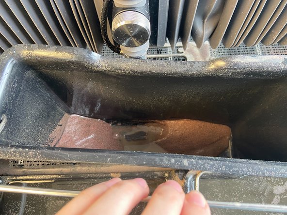 Lift the bucket, drain the excess water into the machine, then dump the used garnet into the used garnet bucket on the right of the cabinet