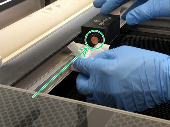 Wipe the window on the left side of the  printer head using a Zeiss wipe