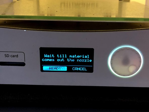 Press the dial when the gears have grabbed on to forward the filament