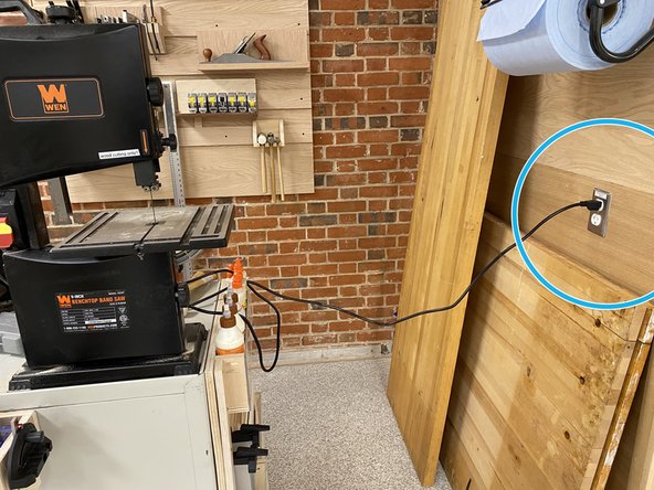 Plug in the band saw in the outlets on the wall to the right.