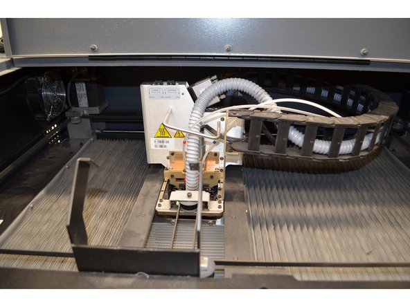 Using both hands, carefully move the head back to its gantry mount and tighten the screws. Be careful not to over tighten