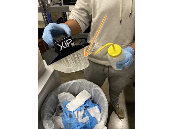 Rinse the model with more IPA and wipe the build plate with a paper towel.