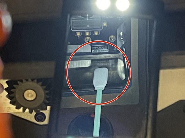 Wipe around the silver side walls  of the upper window in a single direction.