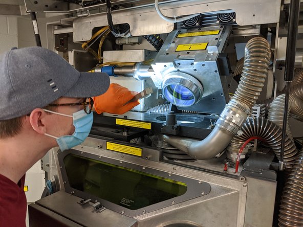 Use the light at an angle to inspect the lens and check for any remaining particles and streaks