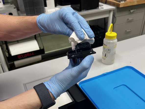 Wipe down the spout with paper towels and clean with IPA over a trash can.