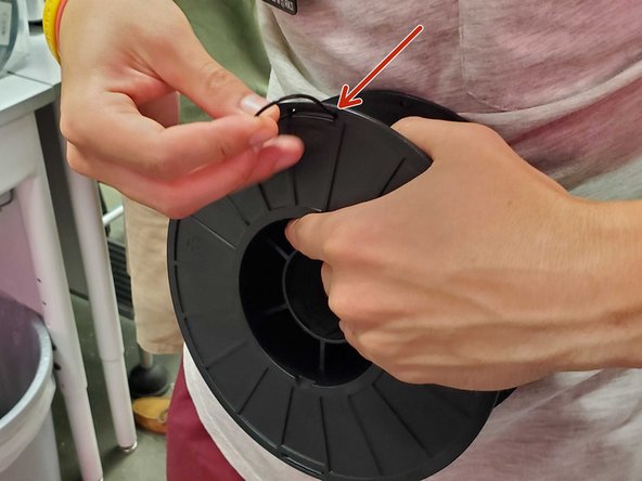 Before putting on a new spool, if you pulled a spool off with material on it, be sure to secure the loose filament in the hole on the side of the spool holder