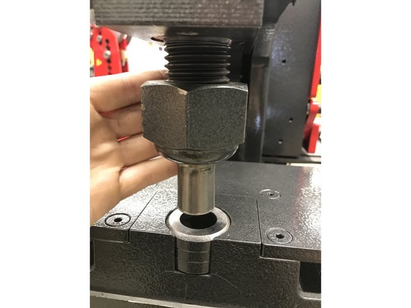 Screw on the large nut containing the die
