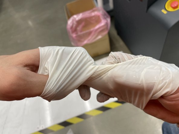 Turn wrists and pull apart in a single motion, slowly to turn the gloves inside out and remove them at the same time