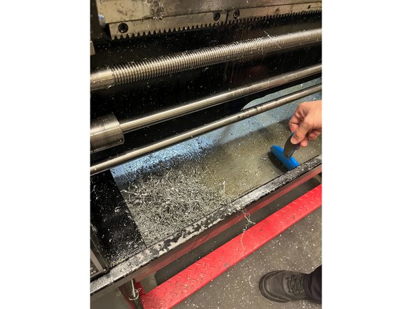 Use the steel wire brush to collect all the chips and shavings into the corner of the tray